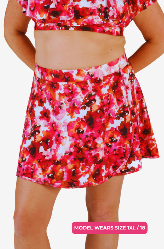 Size 1XL/18 model wearing a red and pink floral high-waisted swim skirt on a grey background