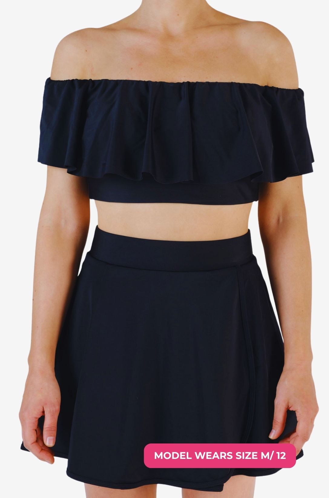 Black off-shoulder swim top and high-waisted swim skirt worn by a model size M/12 set on a grey background