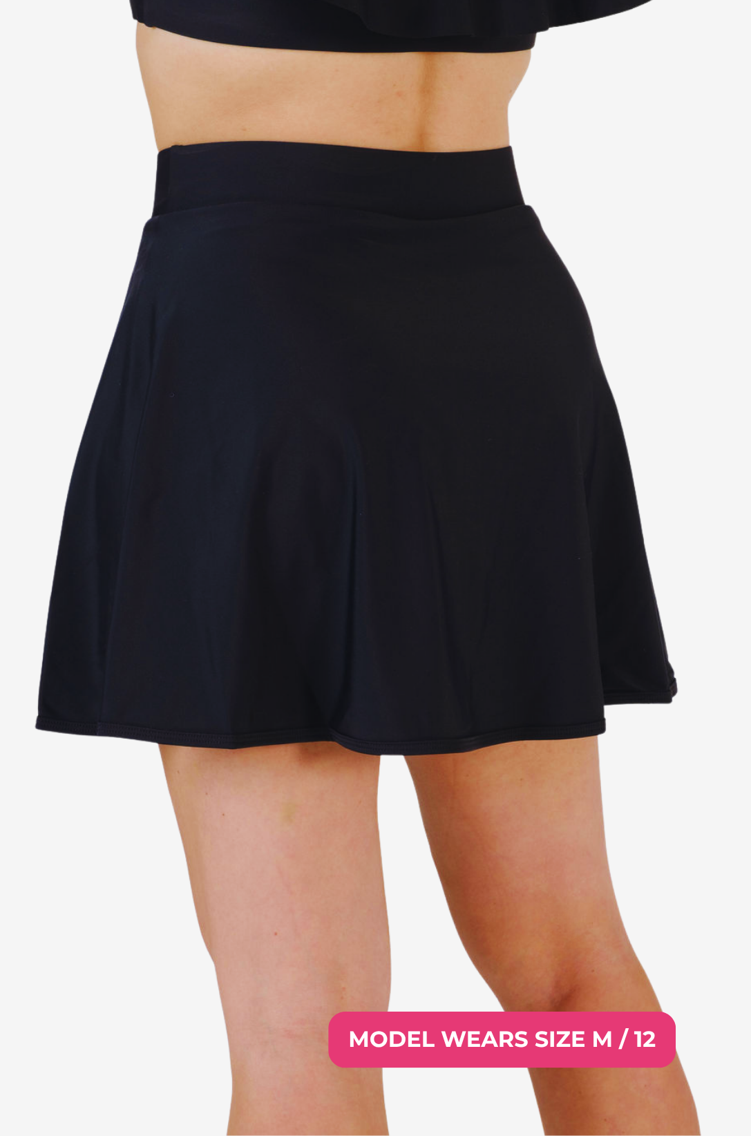 Back angle of a black high-waisted swim skirt worn by a model size M/12 on a grey background