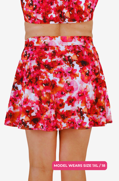 Back view of a floral high-waisted swim skirt on a model size 1XL/18 on a grey background