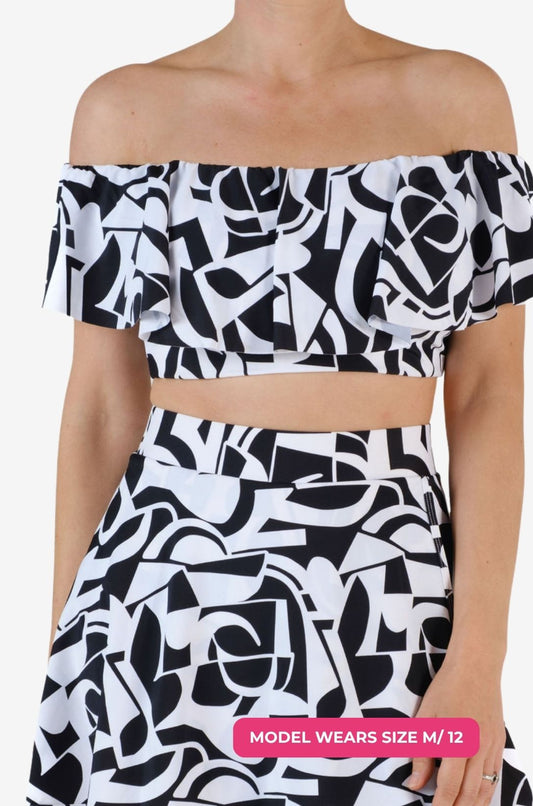 Black and white geometric patterned off-shoulder swim top worn on a model size M/12