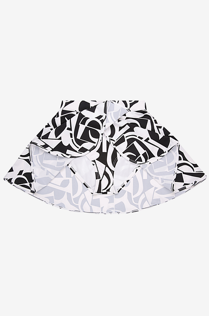 Black and white geometric high-waisted swim skirt on a grey background with brief